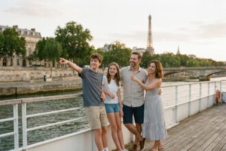 Famille en croisière sur la Seine admirant la Tour Eiffel depuis le pont d'un bateau touristique à Paris
