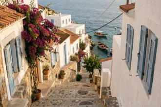 Village traditionnel de Karpathos avec maisons blanches et ruelles pavées surplombant une crique turquoise de la mer Égée