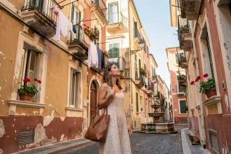 Femme explorant une ruelle pittoresque du Vieux-Nice avec ses façades colorées et ses balcons fleuris
